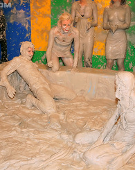Adorable lesbians enjoy wrestling in a tub of dirt and mud